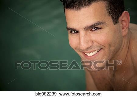 Stock Photo - Smiling Middle Eastern man near swimming pool. Fotosearch