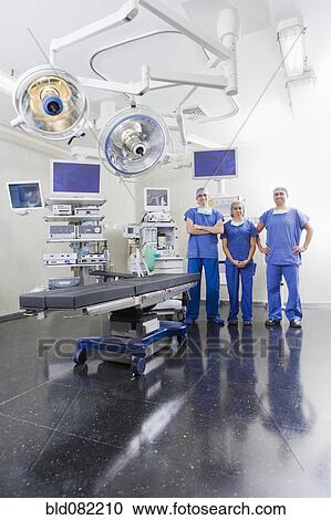 Stock Image - Surgeons in hospital operating room. Fotosearch