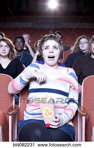 Surprised Caucasian woman eating popcorn in movie theater View Large Photo Image Stock Image - Surprised Caucasian woman eating popcorn in movie theater. Fotosearch