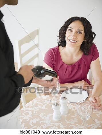 Waiter showing wine bottle to customer at table in restaurant View Large Photo Image Stock Photo - Waiter showing wine bottle to customer at table in restaurant. Fotosearch