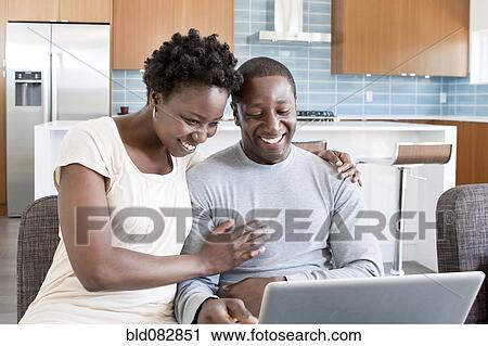 Black couple hugging and using laptop View Large Photo Image Stock Image - Black couple hugging and using laptop. Fotosearch