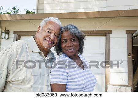 Stock Image - Black couple standing together in driveway. Fotosearch