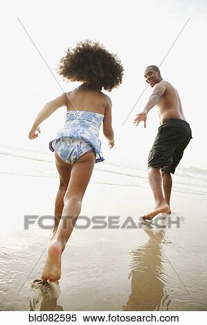 Black father holding out hand to daughter on beach View Large Photo Image Stock Photography - Black father holding out hand to daughter on beach. Fotosearch