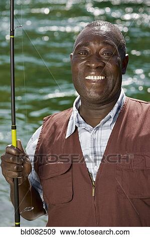 Black Man With Cell Phone Fishing In Stream Stock Photo Alamy