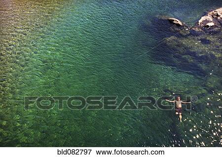 Stock Photo - Caucasian man swimming in ocean. Fotosearch