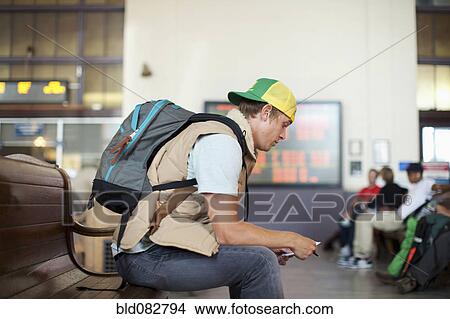 Picture - Caucasian man waiting in train station. Fotosearch