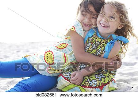 Stock Image - Children hugging on beach. Fotosearch