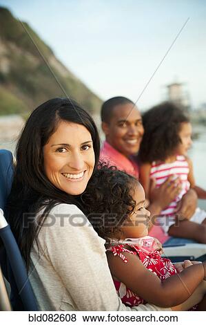 Family sitting together on beach View Large Photo Image Stock Photo - Family sitting together on beach. Fotosearch