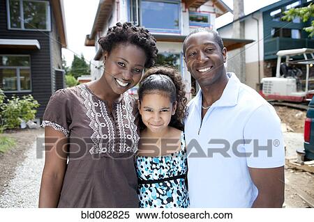 Stock Photography - Family standing near house under construction. Fotosearch