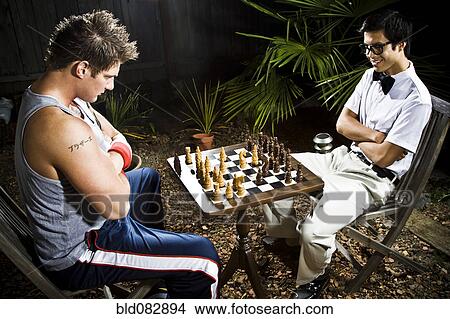 Picture - Geek and body builder playing chess. Fotosearch