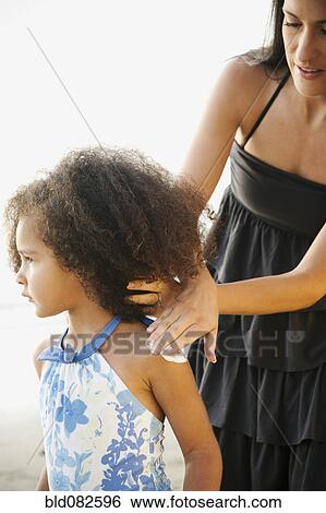 Hispanic mother rubbing sunscreen on daughter at beach View Large Photo Image Stock Photograph - Hispanic mother rubbing sunscreen on daughter at beach. Fotosearch