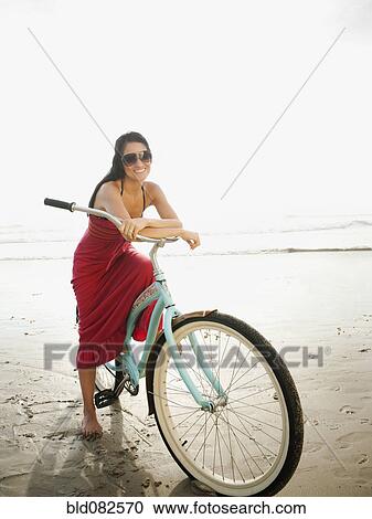 Hispanic woman riding retro bicycle on beach View Large Photo Image Stock Image - Hispanic woman riding retro bicycle on beach. Fotosearch