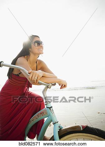 Hispanic woman riding retro bicycle on beach View Large Photo Image Stock Image - Hispanic woman riding retro bicycle on beach. Fotosearch