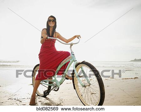 Hispanic woman riding retro bicycle on beach View Large Photo Image Stock Photo - Hispanic woman riding retro bicycle on beach. Fotosearch