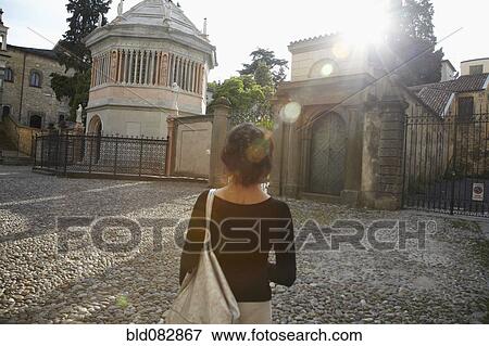 Stock Photo - Italian woman standing near gates of building. Fotosearch