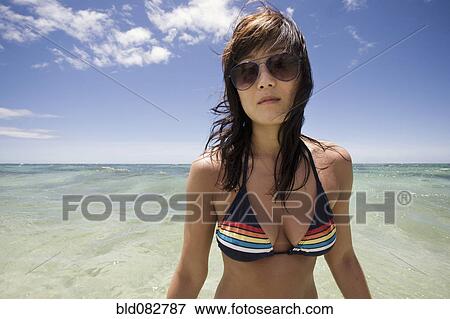 Stock Photo - Korean woman in bikini with ocean in background. Fotosearch
