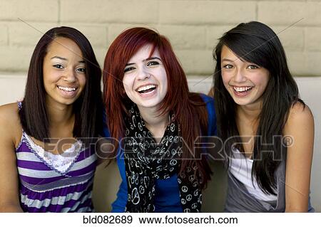 Laughing girls sitting together View Large Photo Image Stock Photo - Laughing girls sitting together. Fotosearch