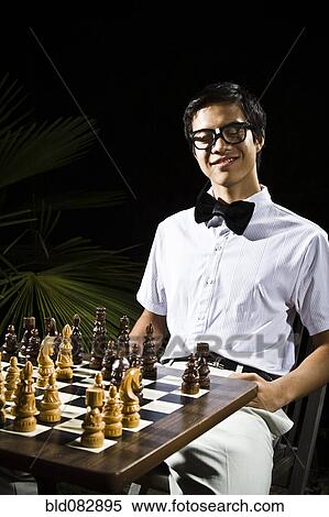 Mixed race geek playing chess View Large Photo Image Stock Photography - Mixed race geek playing chess. Fotosearch