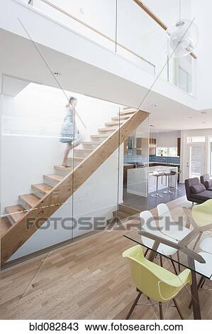 Stock Image - Mixed race girl walking up staircase. Fotosearch