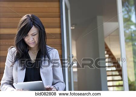 Stock Photo - Mixed race real estate agent using digital tablet. Fotosearch