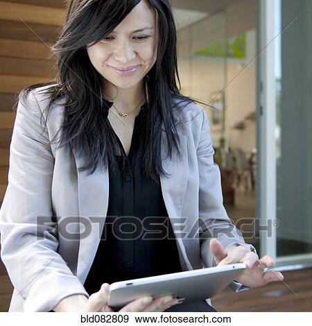 Mixed race real estate agent using digital tablet View Large Photo Image Stock Photo - Mixed race real estate agent using digital tablet. Fotosearch