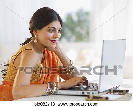 Mixed race woman in traditional Indian clothing using laptop View Large Photo Image Stock Image - Mixed race woman in traditional Indian clothing using laptop. Fotosearch