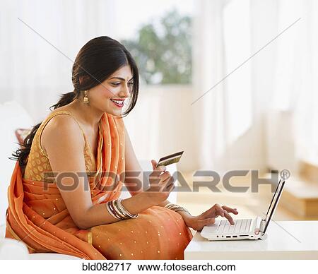 Mixed race woman in traditional Indian clothing using credit card online View Large Photo Image Stock Photo - Mixed race woman in traditional Indian clothing using credit card online. Fotosearch