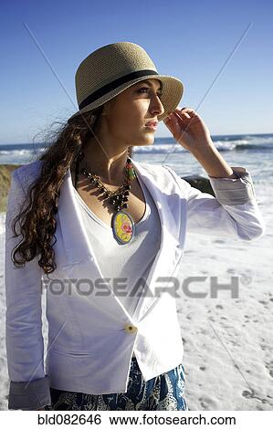 Mixed race woman wearing hat at beach View Large Photo Image Stock Photograph - Mixed race woman wearing hat at beach. Fotosearch
