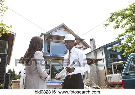 Real estate agents near house under construction View Large Photo Image Stock Photograph - Real estate agents near house under construction. Fotosearch