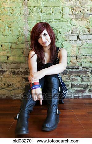 Stock Image - Redheaded teenager leaning against wall. Fotosearch