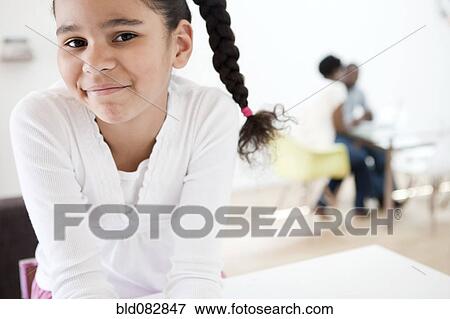 Smiling girl with parents in background View Large Photo Image Stock Photo - Smiling girl with parents in background. Fotosearch