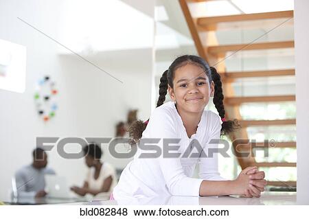 Smiling girl with parents in background View Large Photo Image Stock Photo - Smiling girl with parents in background. Fotosearch