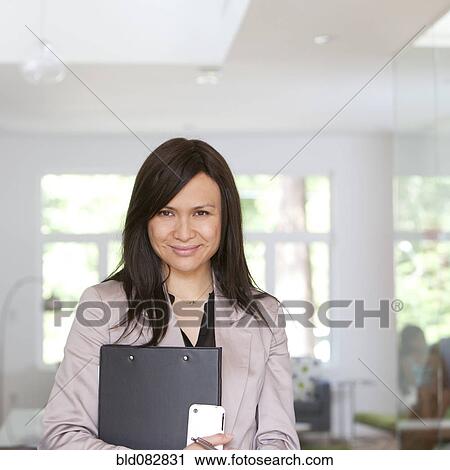 Stock Image - Smiling real estate agent standing in home. Fotosearch