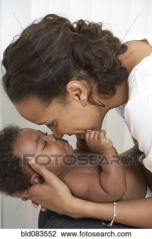 Stock Image - African American mother caressing baby. Fotosearch