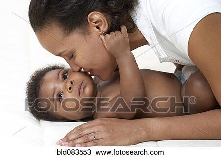 Stock Image - African American mother kissing baby. Fotosearch