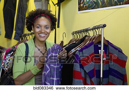 Stock Photograph - African American shopper in clothing shop. Fotosearch