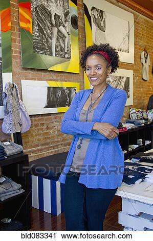 Stock Image - African American small business owner in clothing shop. Fotosearch