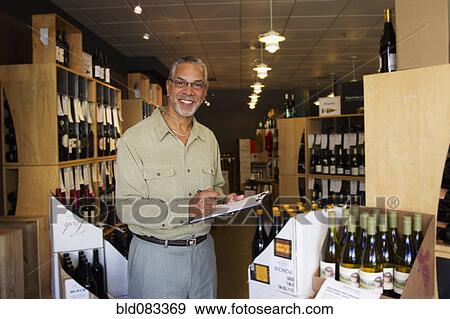 Stock Photo - African American small business owner working in wine shop. Fotosearch