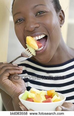 African American woman eating fruit salad View Large Photo Image Stock Photo - African American woman eating fruit salad. Fotosearch