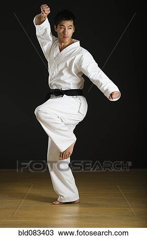 Stock Image - Asian male black belt practicing karate. Fotosearch