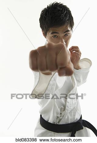 Stock Photo - Asian male karate black belt punching. Fotosearch