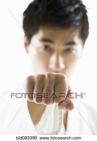Stock Photo - Asian male karate black belt punching. Fotosearch