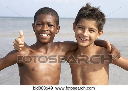 Stock Photo - Boys on beach giving the thumbs up sign. Fotosearch