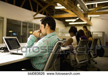 Stock Photograph - Business people working on communal workspace. Fotosearch