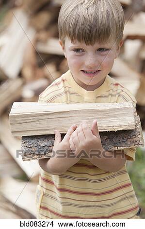 Caucasian boy carrying firewood View Large Photo Image Picture - Caucasian boy carrying firewood. Fotosearch