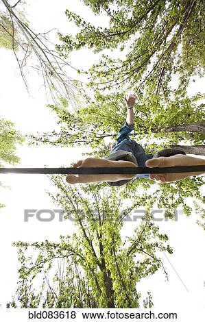 Caucasian man balancing on rope in park View Large Photo Image Stock Photo - Caucasian man balancing on rope in park. Fotosearch