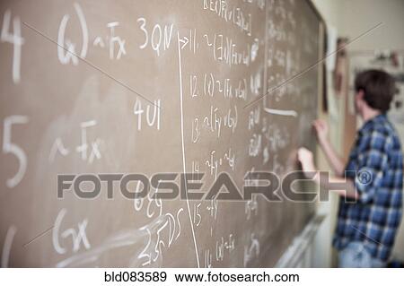 Stock Photo - Caucasian student writing on blackboard. Fotosearch