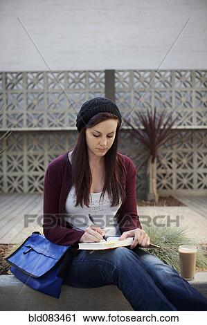 Caucasian woman writing in journal outdoors View Large Photo Image Stock Image - Caucasian woman writing in journal outdoors. Fotosearch