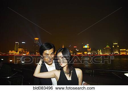 Chinese couple hugging on city waterfront View Large Photo Image Stock Photograph - Chinese couple hugging on city waterfront. Fotosearch