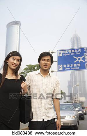 Stock Photo - Chinese couple walking in urban area. Fotosearch
